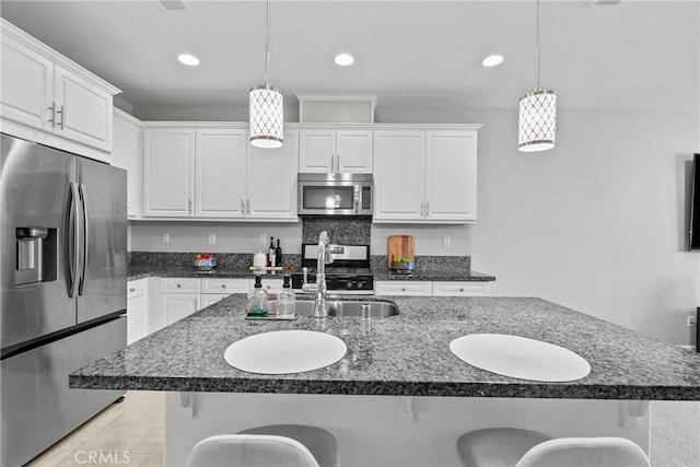 2894 E Via Fiano, Ontario, CA 91764 - kitchen featuring appliances with stainless steel finishes, a kitchen bar, white cabinets, hanging light fixtures, and recessed lighting
