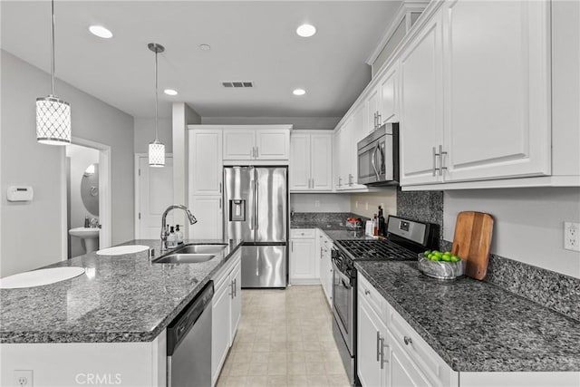 2894 E Via Fiano, Ontario, CA 91764 - kitchen featuring appliances with stainless steel finishes, white cabinets, decorative light fixtures, recessed lighting, and dark stone counters