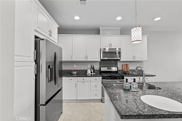 2894 E Via Fiano, Ontario, CA 91764 - kitchen featuring stainless steel appliances, white cabinets, pendant lighting, dark stone countertops, and recessed lighting