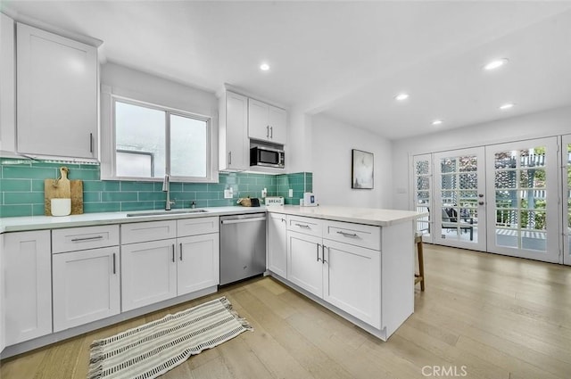 569 Lewis Ave, San Leandro, CA 94577 - kitchen with stainless steel appliances, a peninsula, white cabinetry, light countertops, and recessed lighting