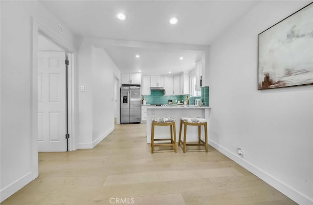 569 Lewis Ave, San Leandro, CA 94577 - kitchen featuring stainless steel fridge, white cabinetry, recessed lighting, a peninsula, and under cabinet range hood
