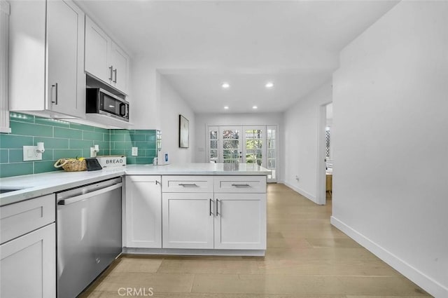569 Lewis Ave, San Leandro, CA 94577 - kitchen with stainless steel appliances, a peninsula, light countertops, backsplash, and recessed lighting