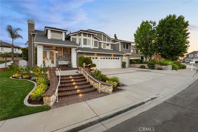 5210 Avenida De Kristine, Yorba Linda, CA 92887 - view of front of home with concrete driveway, stone siding, an attached garage, a chimney, and french doors