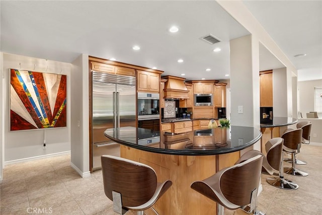 5210 Avenida De Kristine, Yorba Linda, CA 92887 - kitchen with built in appliances, custom range hood, a kitchen breakfast bar, dark countertops, and recessed lighting