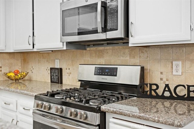371 N Melrose Dr Unit A, Vista, CA 92083 - kitchen featuring appliances with stainless steel finishes, white cabinetry, decorative backsplash, and light stone countertops