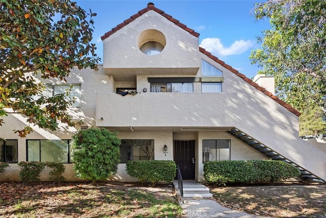 371 N Melrose Dr Unit A, Vista, CA 92083 - view of front of property featuring stucco siding, a tile roof, and a balcony
