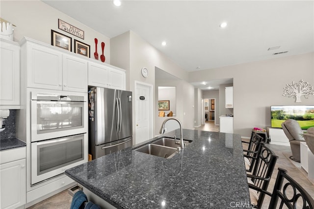33818 Channel St, Temecula, CA 92592 - kitchen with freestanding refrigerator, double oven, a kitchen bar, recessed lighting, and white cabinets