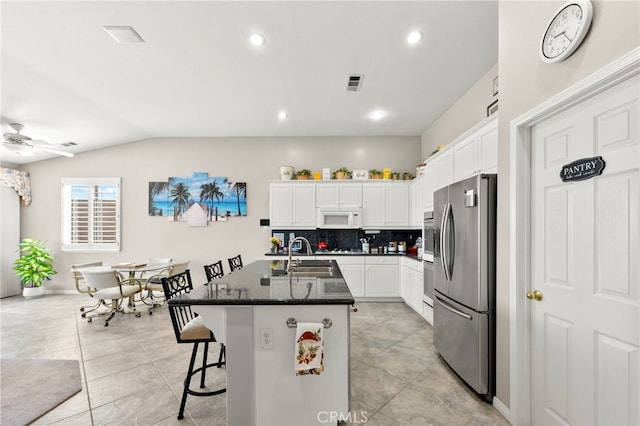 33818 Channel St, Temecula, CA 92592 - kitchen featuring stainless steel fridge, white microwave, backsplash, white cabinetry, and recessed lighting