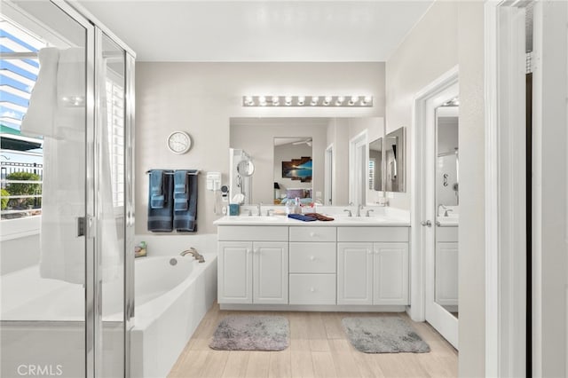 33818 Channel St, Temecula, CA 92592 - bathroom featuring double vanity, a stall shower, a garden tub, and wood finished floors