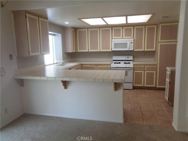2425 Dixie St, Rosamond, CA 93560 - kitchen with white appliances, a peninsula, light brown cabinets, tile counters, and light colored carpet