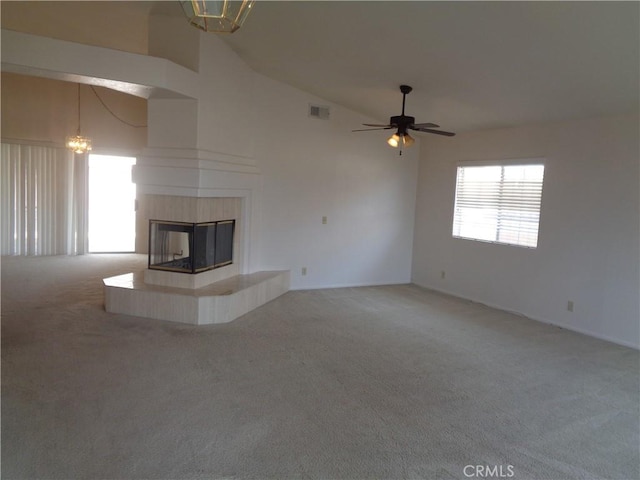 2425 Dixie St, Rosamond, CA 93560 - unfurnished living room featuring light carpet, vaulted ceiling, a tile fireplace, a chandelier, and a ceiling fan