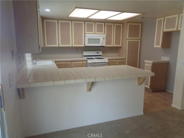 2425 Dixie St, Rosamond, CA 93560 - kitchen with white appliances, a peninsula, tile countertops, light brown cabinetry, and light carpet