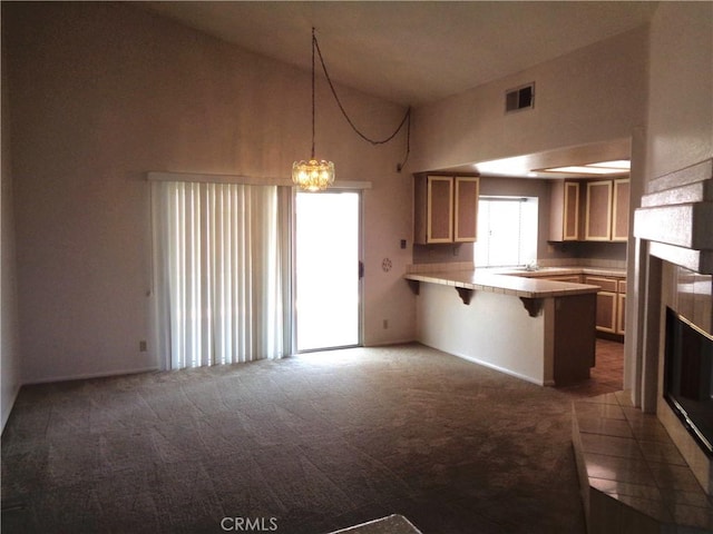 2425 Dixie St, Rosamond, CA 93560 - kitchen with carpet, a peninsula, a breakfast bar, light countertops, and high vaulted ceiling