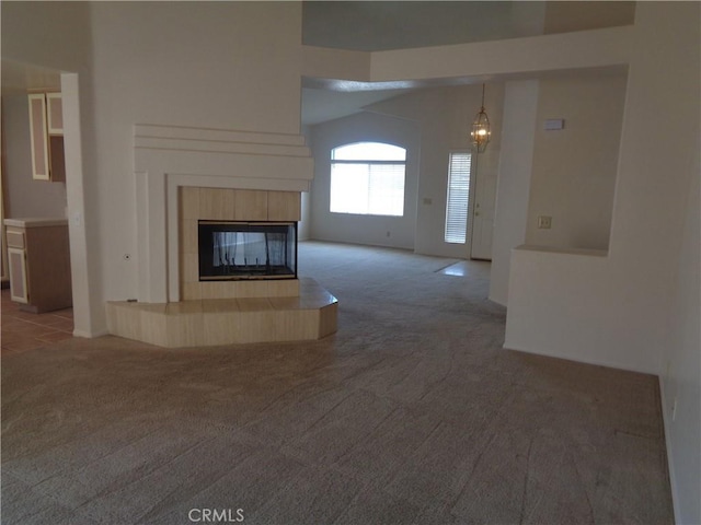 2425 Dixie St, Rosamond, CA 93560 - unfurnished living room featuring light colored carpet, a chandelier, a tile fireplace, and lofted ceiling