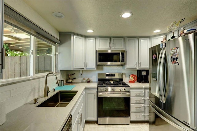 990 E Main St Unit A, El Cajon, CA 92021 - kitchen with appliances with stainless steel finishes, tasteful backsplash, a textured ceiling, light stone countertops, and recessed lighting