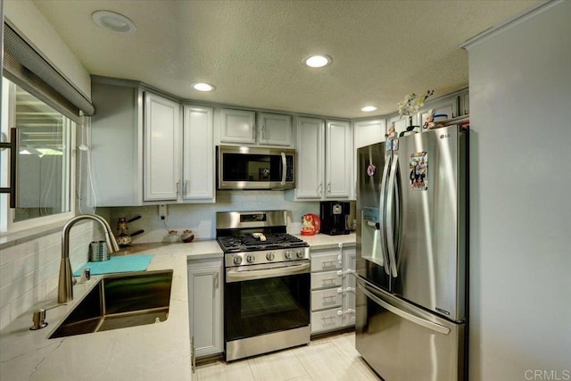 990 E Main St Unit A, El Cajon, CA 92021 - kitchen with appliances with stainless steel finishes, a textured ceiling, recessed lighting, light stone counters, and tasteful backsplash