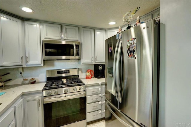 990 E Main St Unit A, El Cajon, CA 92021 - kitchen featuring appliances with stainless steel finishes, a textured ceiling, recessed lighting, light stone countertops, and tasteful backsplash