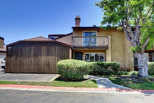 990 E Main St Unit A, El Cajon, CA 92021 - view of front facade with a balcony, stucco siding, and a chimney