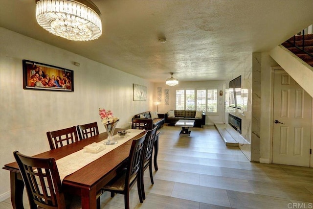 990 E Main St Unit A, El Cajon, CA 92021 - dining room featuring a chandelier, a fireplace, and a textured ceiling