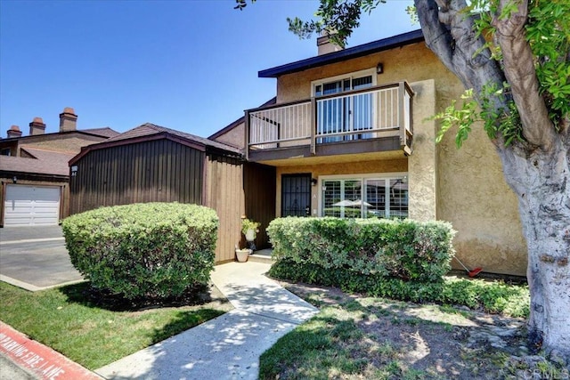 990 E Main St Unit A, El Cajon, CA 92021 - view of front of home featuring a balcony, a chimney, and stucco siding