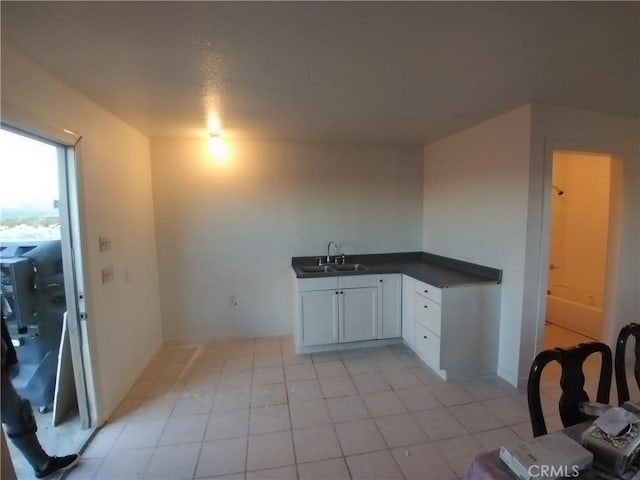 40575 Summerset Rd, Newberry Springs, CA 92365 - kitchen with dark countertops, light tile patterned flooring, and white cabinets