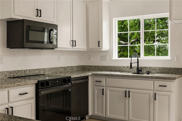 255 Sparrow Ct, Red Bluff, CA 96080 - kitchen with black appliances, white cabinets, and light stone counters