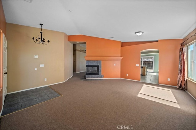 5715 Malaga Ct, Palmdale, CA 93552 - unfurnished living room featuring carpet floors, arched walkways, a tile fireplace, a chandelier, and lofted ceiling