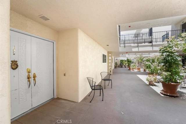 2385 Via Mariposa Unit 1F, Laguna Woods, CA 92637 - doorway to property featuring stucco siding