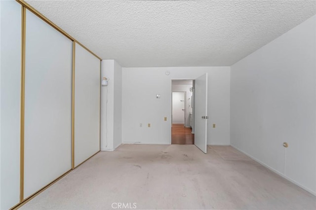 2385 Via Mariposa Unit 1F, Laguna Woods, CA 92637 - unfurnished bedroom with carpet, a closet, and a textured ceiling