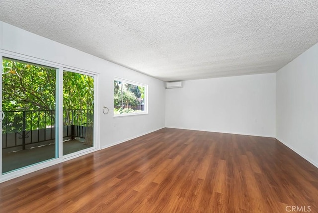 2385 Via Mariposa Unit 1F, Laguna Woods, CA 92637 - unfurnished room with a wall unit AC, wood finished floors, and a textured ceiling
