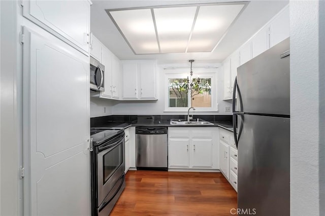 2385 Via Mariposa Unit 1F, Laguna Woods, CA 92637 - kitchen featuring stainless steel appliances, dark countertops, white cabinetry, and dark wood-style floors