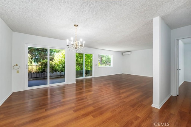 2385 Via Mariposa Unit 1F, Laguna Woods, CA 92637 - empty room with a chandelier, wood finished floors, a textured ceiling, and a wall mounted AC