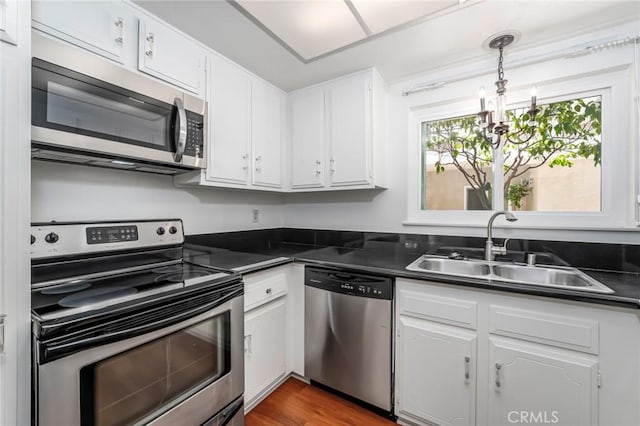 2385 Via Mariposa Unit 1F, Laguna Woods, CA 92637 - kitchen with stainless steel appliances, dark countertops, and white cabinetry