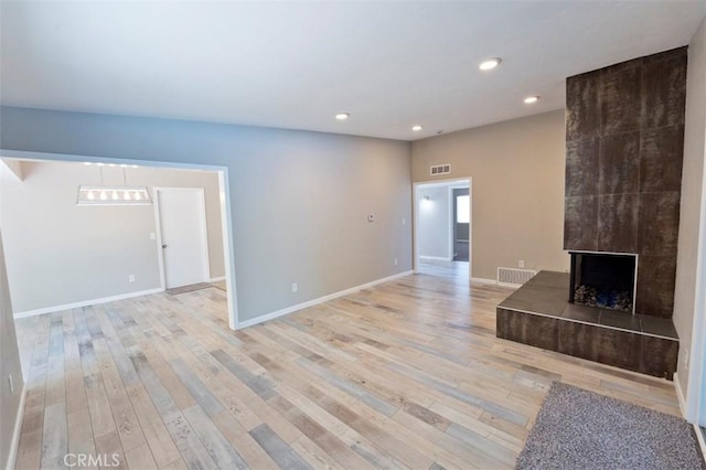 4001 Rinker Way, Bakersfield, CA 93309 - unfurnished living room with recessed lighting, light wood-type flooring, and a tile fireplace