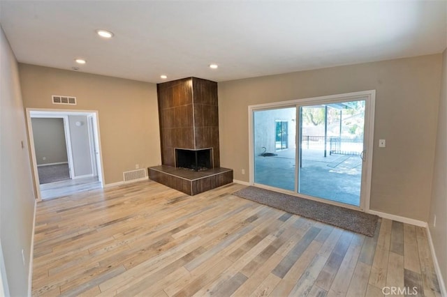4001 Rinker Way, Bakersfield, CA 93309 - unfurnished living room featuring light wood finished floors, recessed lighting, and a tile fireplace