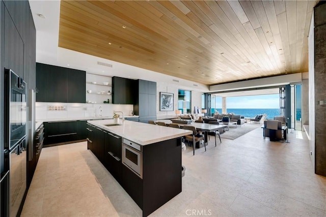 35411 Beach Rd, Dana Point, CA 92624 - kitchen with wood ceiling, modern cabinets, dark cabinets, open shelves, and an island with sink