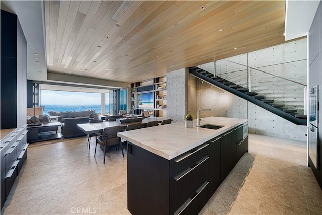 35411 Beach Rd, Dana Point, CA 92624 - kitchen featuring dark cabinetry, an island with sink, open floor plan, modern cabinets, and wood ceiling