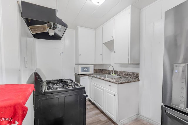 136 N Garfield Ave, Oxnard, CA 93030 - kitchen with freestanding refrigerator, ventilation hood, black gas range, and white cabinets