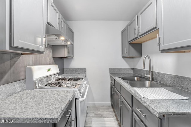136 N Garfield Ave, Oxnard, CA 93030 - kitchen featuring white range with gas stovetop, gray cabinets, exhaust hood, and light countertops