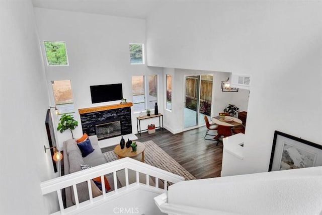37 Conch Reef, Aliso Viejo, CA 92656 - living room featuring plenty of natural light, wood finished floors, a glass covered fireplace, a towering ceiling, and a chandelier