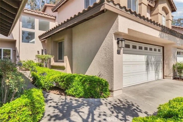 37 Conch Reef, Aliso Viejo, CA 92656 - view of home's exterior featuring stucco siding, driveway, an attached garage, and a tiled roof