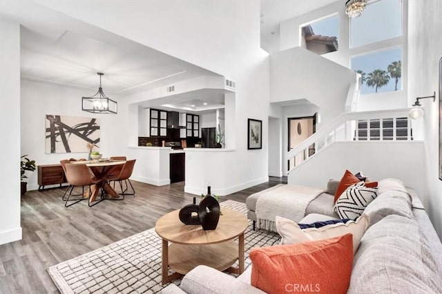 37 Conch Reef, Aliso Viejo, CA 92656 - living room featuring a chandelier, wood finished floors, stairway, and a towering ceiling