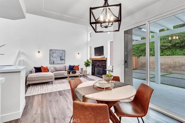 37 Conch Reef, Aliso Viejo, CA 92656 - dining space featuring wood finished floors, a fireplace, a chandelier, and a towering ceiling