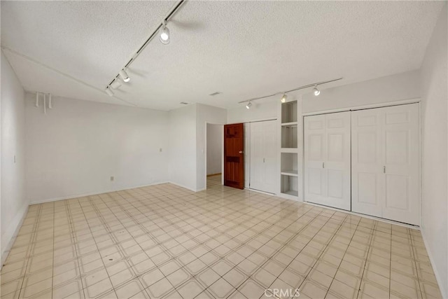 8291 Jennet St, Rancho Cucamonga, CA 91701 - unfurnished bedroom with track lighting, a textured ceiling, and multiple closets