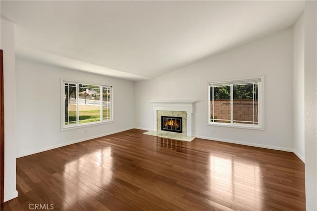 8291 Jennet St, Rancho Cucamonga, CA 91701 - unfurnished living room featuring healthy amount of natural light, lofted ceiling, dark wood-style floors, and a high end fireplace