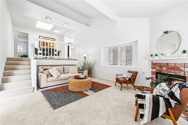 18051 Wakefield Ln Unit 106, Huntington Beach, CA 92648 - living room with carpet floors, a brick fireplace, stairway, and a skylight