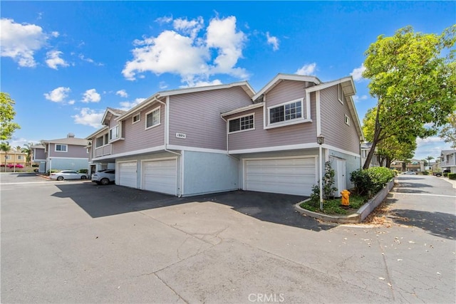 18051 Wakefield Ln Unit 106, Huntington Beach, CA 92648 - view of front of home with an attached garage, a residential view, and driveway