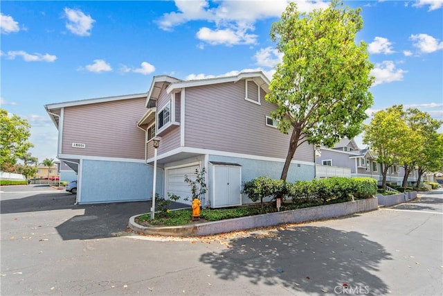 18051 Wakefield Ln Unit 106, Huntington Beach, CA 92648 - view of home's exterior featuring driveway, a garage, and stucco siding