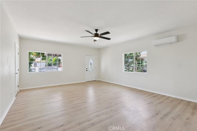 2422 E 115th St, Los Angeles, CA 90059 - empty room with an AC wall unit, plenty of natural light, light wood finished floors, and a ceiling fan