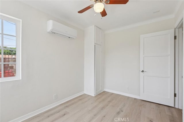 2422 E 115th St, Los Angeles, CA 90059 - unfurnished bedroom featuring a wall unit AC, light wood-style flooring, and ceiling fan